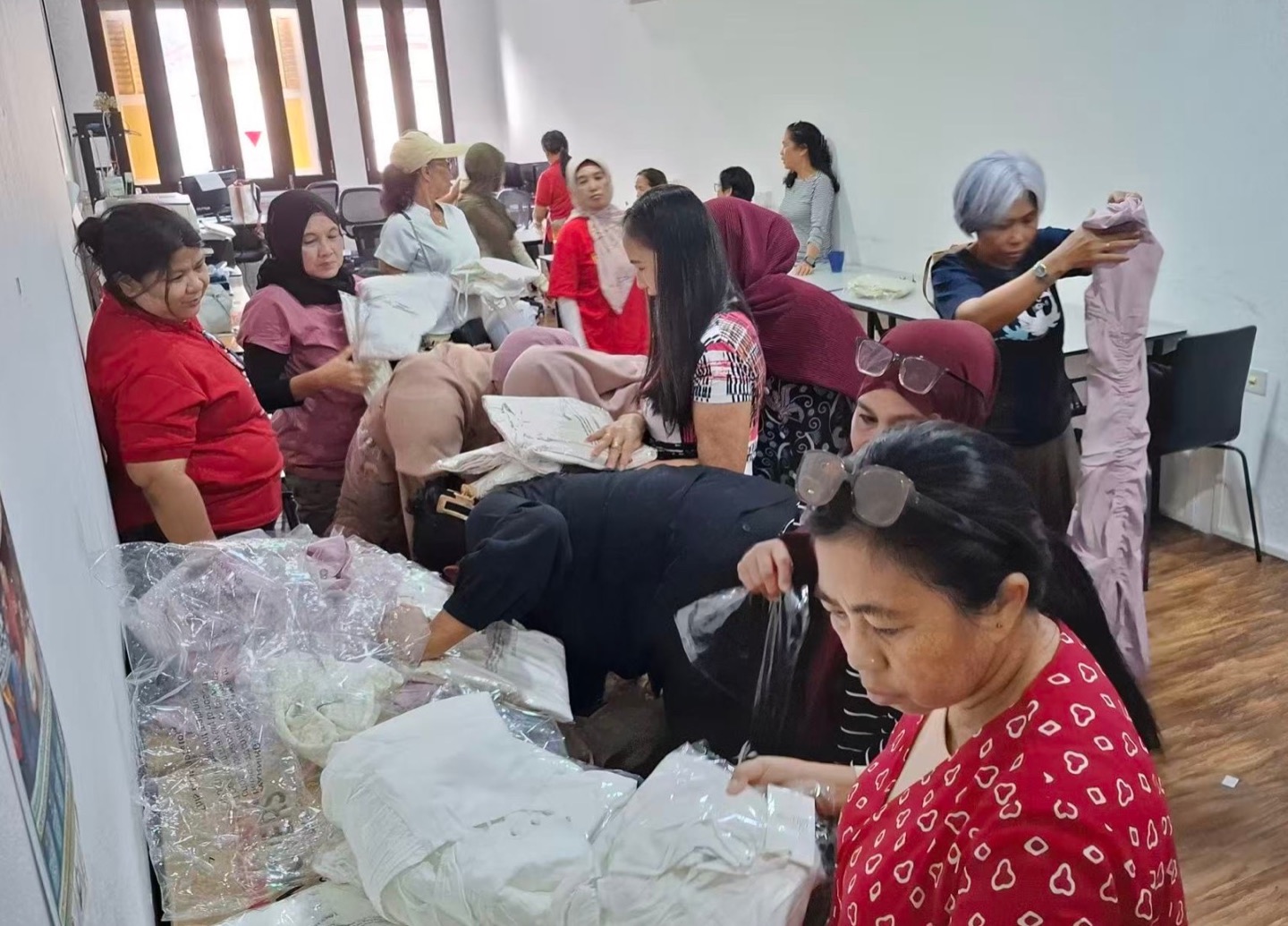 Adults examining and holding clothing around a table