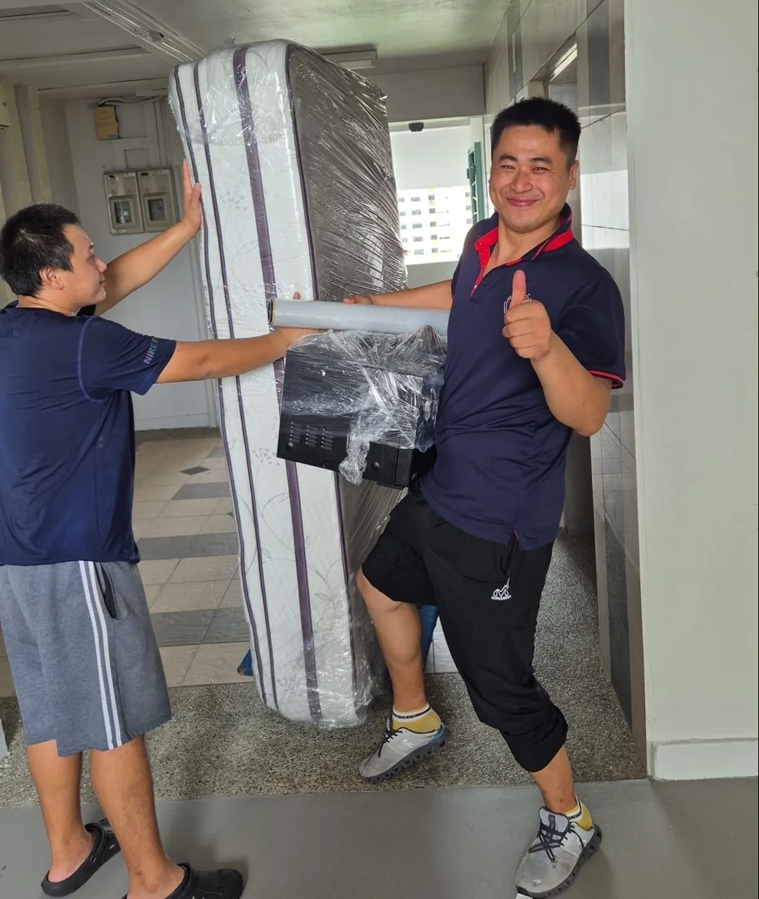 Move Move crew handling a wrapped mattress at a residential doorway