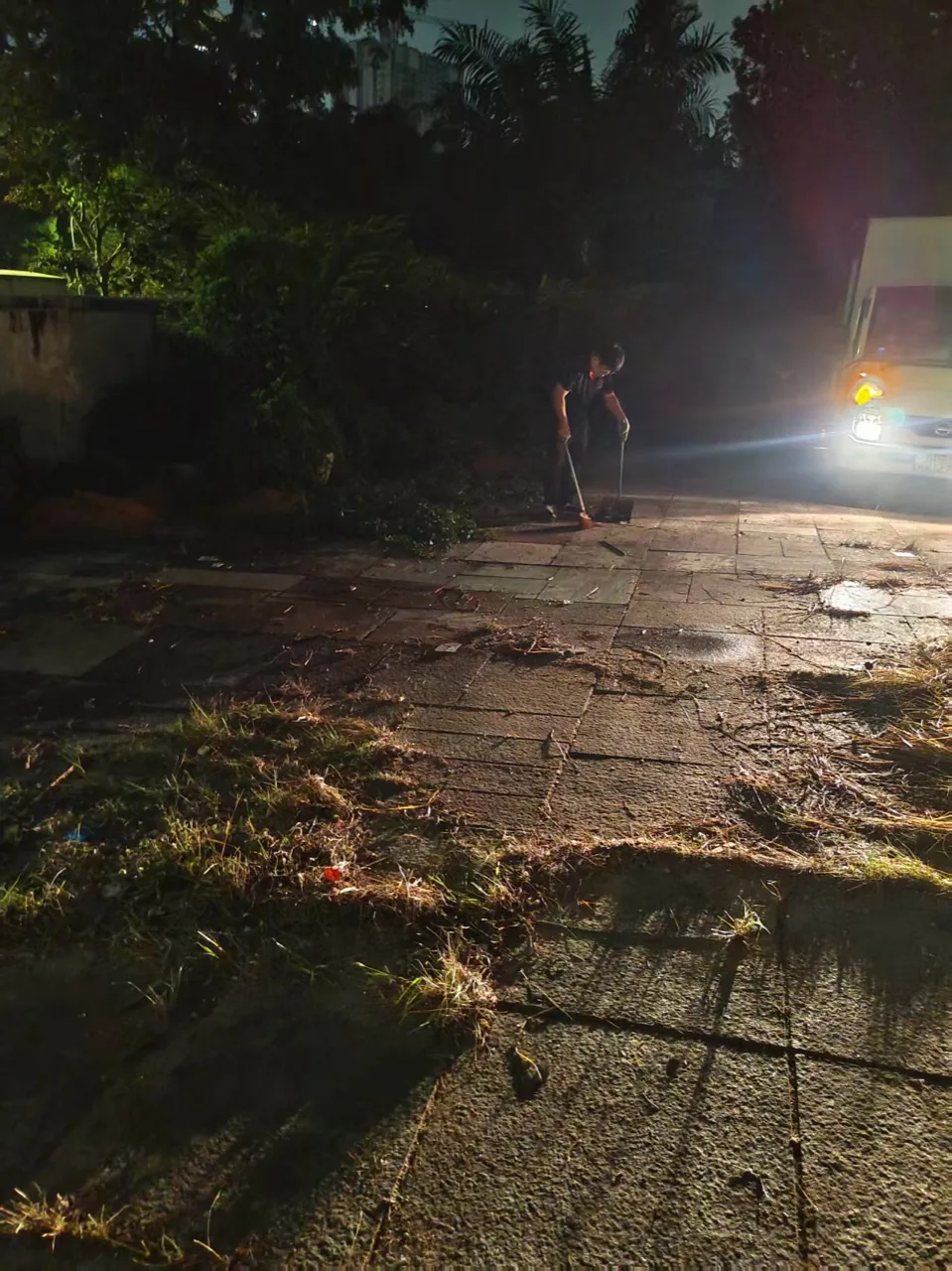 Move Move team member sweeping the paved access area during the Bukit Timah house clearance