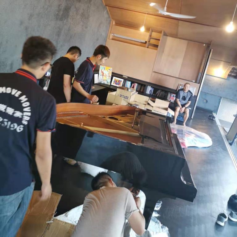 Move Move Movers crew preparing a grand piano for transport