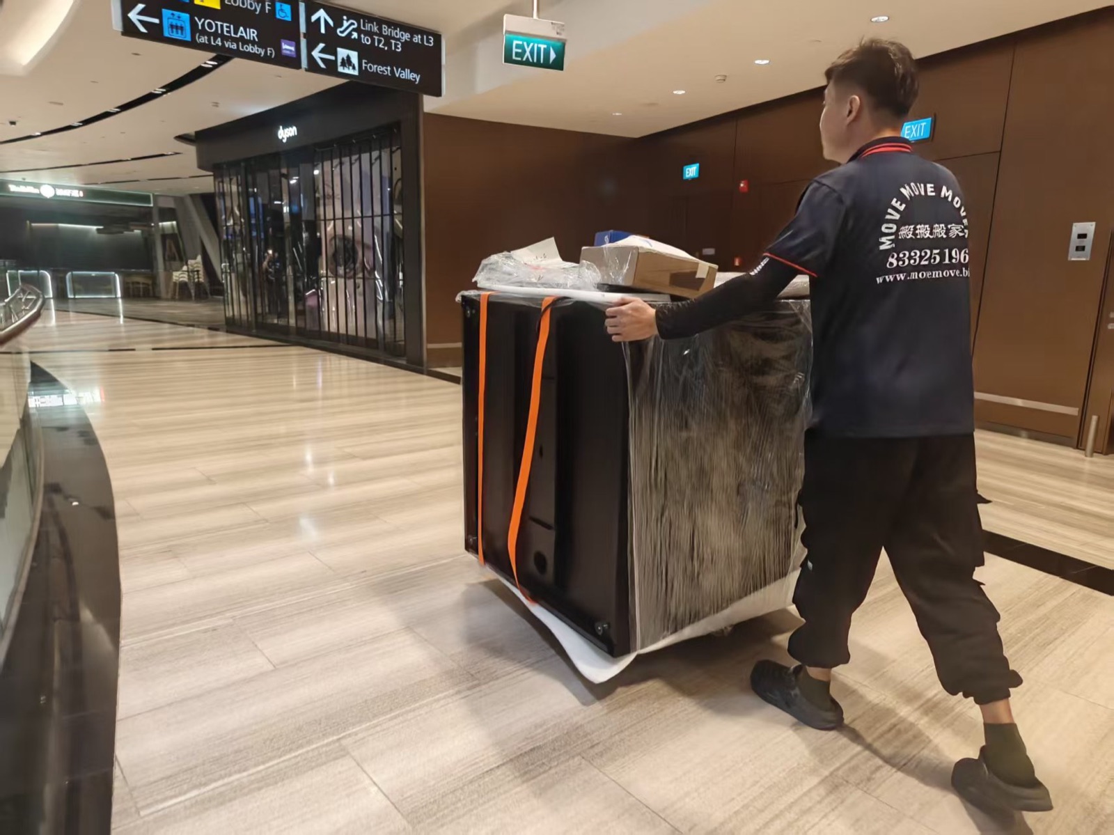 Move Move Movers crew member guiding a protected Dyson retail fixture along an indoor route in Singapore