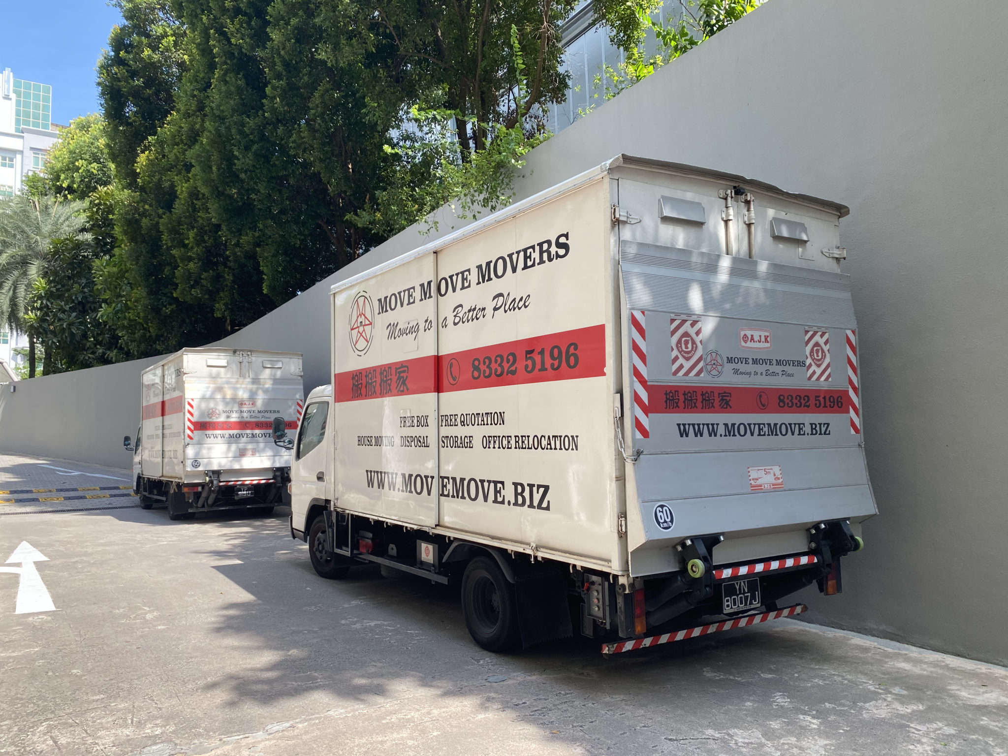 两辆 Move Move Movers 货车停在新加坡住宅车道，准备进行住宅搬运