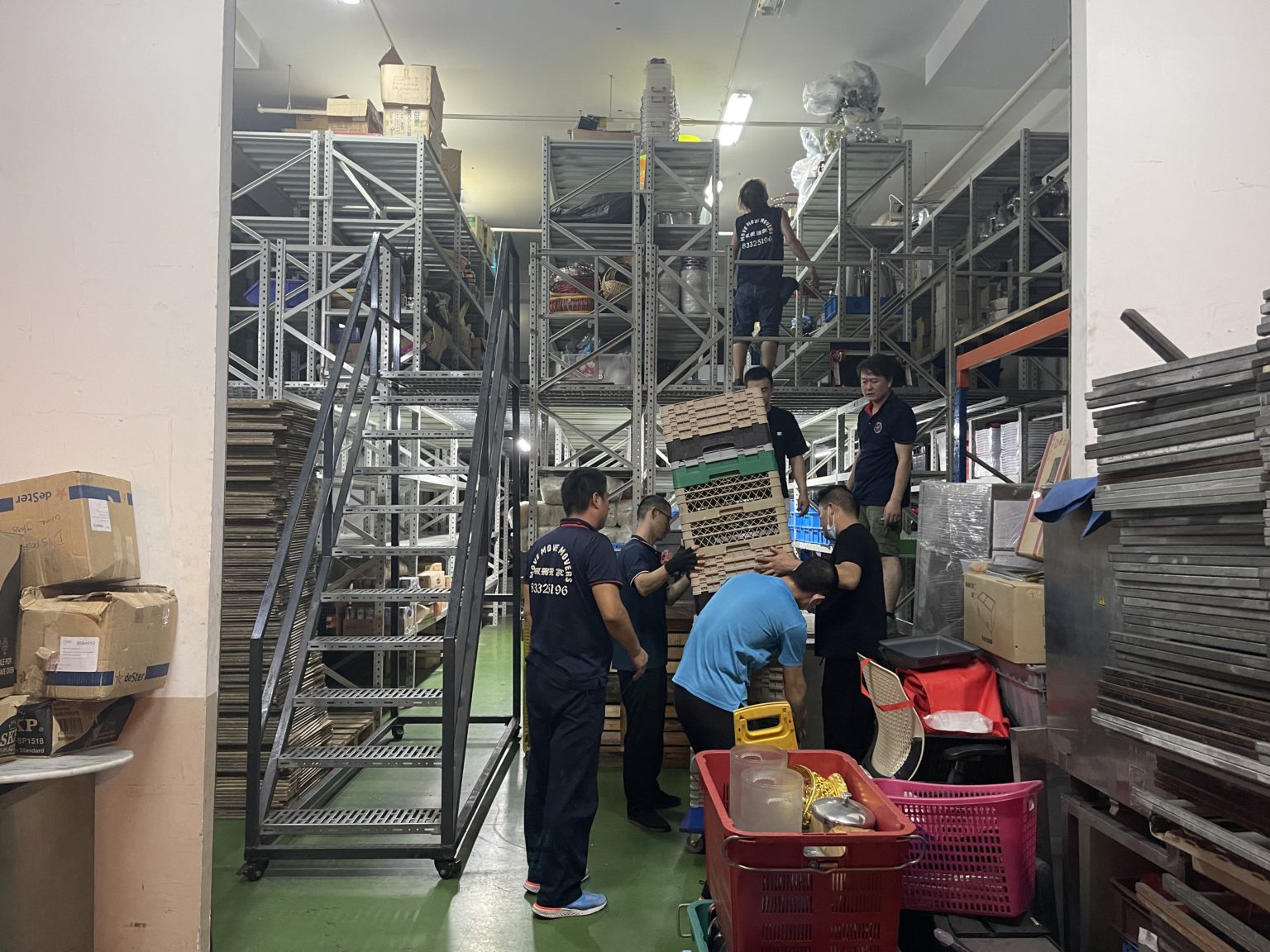 Move Move Movers crew organising stored items on warehouse racking in Singapore