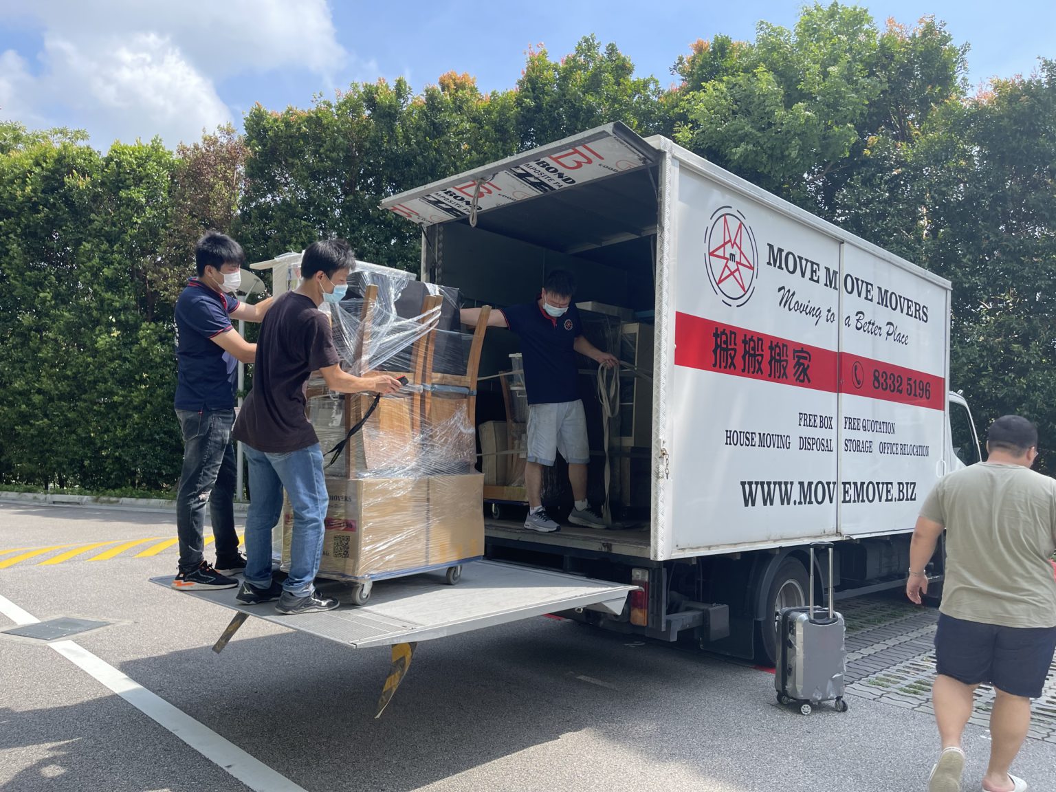 Move Move Movers crew loading wrapped household furniture into a branded lorry in Singapore