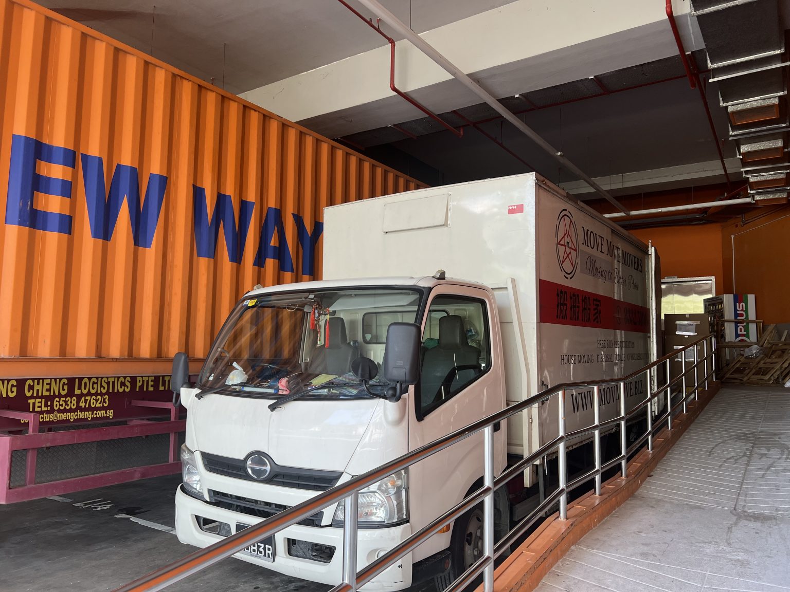 Move Move Movers lorry positioned at an industrial loading ramp in Singapore
