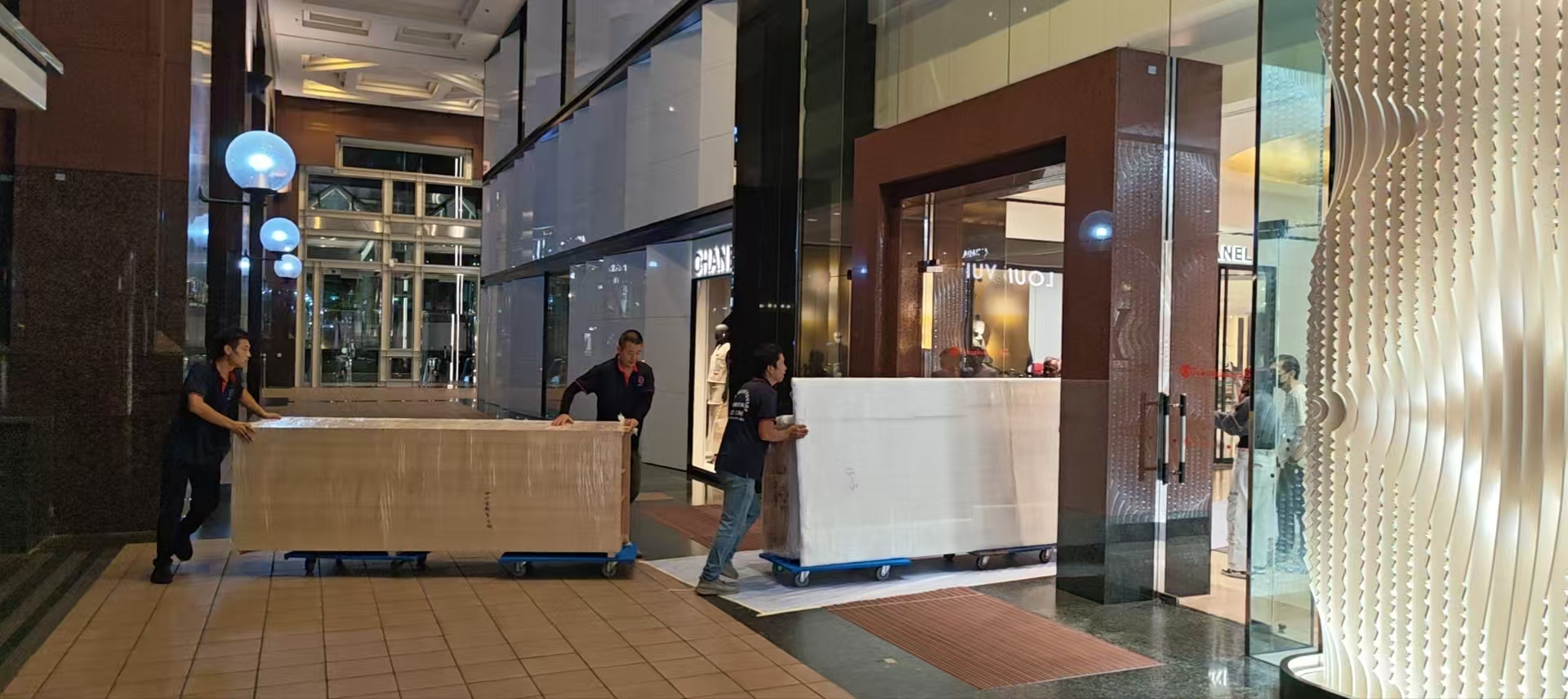 Platform trolley carrying boxed commercial items through a retail-style corridor in Singapore