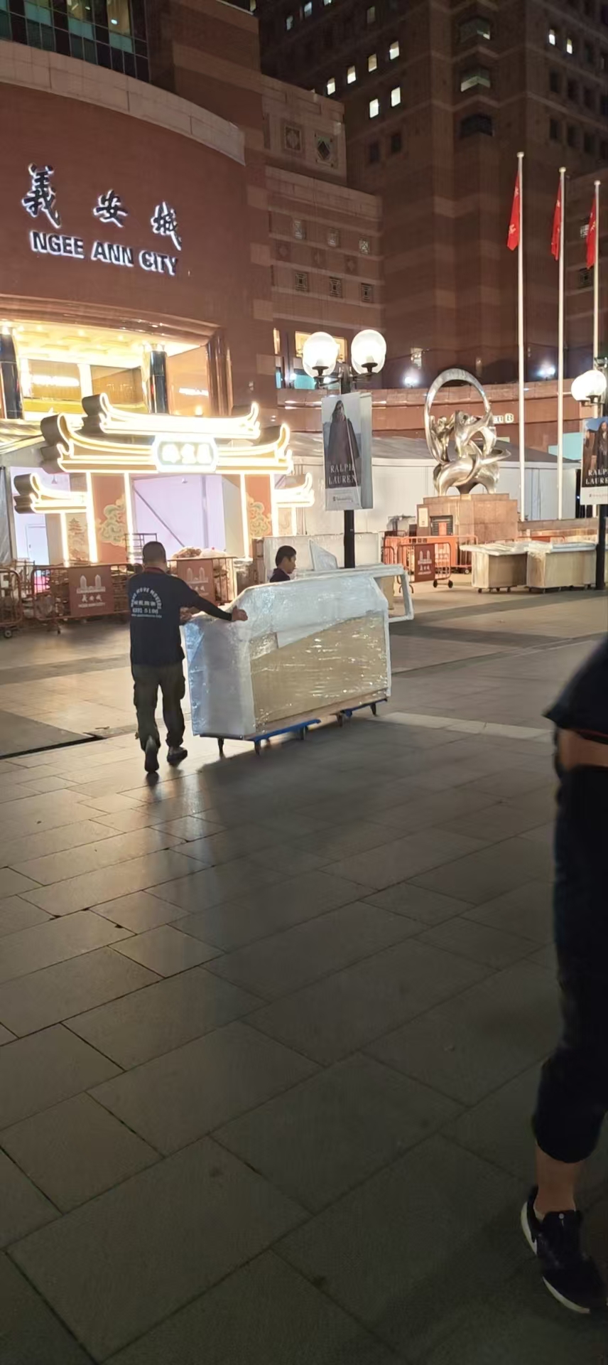 Retail relocation crew moving assets through a shopping mall interior in Singapore