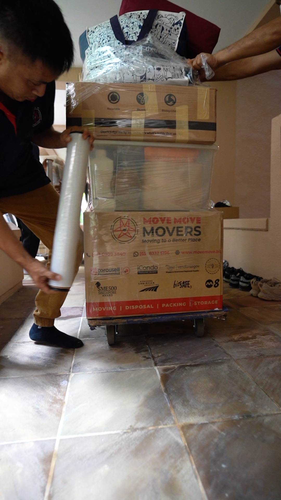 Boxes and household items staged on a trolley for home disposal planning in Singapore