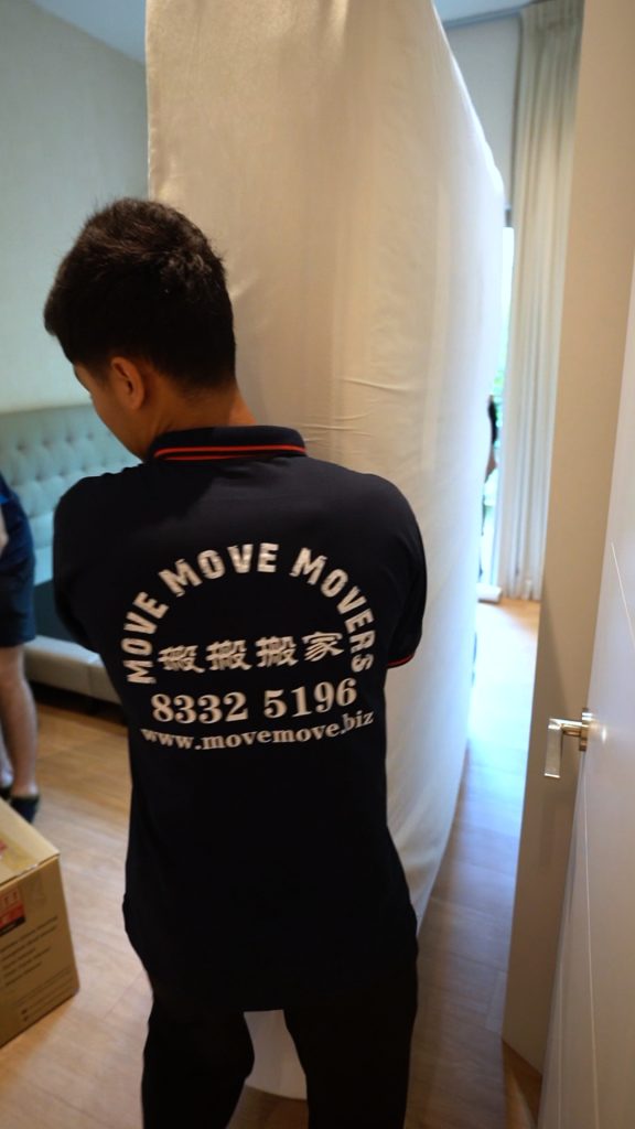 Move Move Movers staff carrying a wrapped mattress through a bedroom doorway