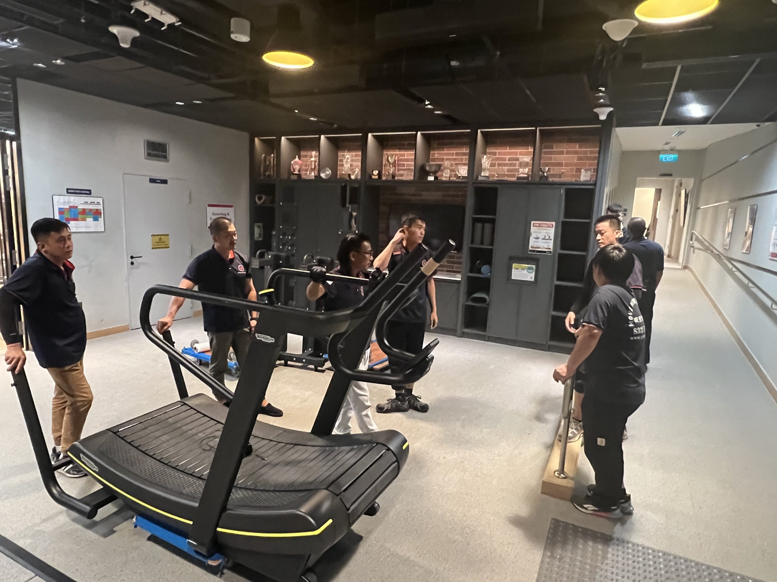 Commercial team carrying a larger item through a modern office lobby in Singapore