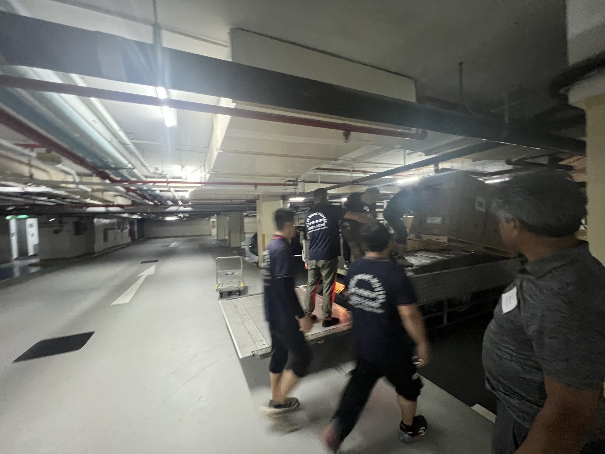 Move Move Movers crew and vehicles staged in a commercial basement loading area in Singapore