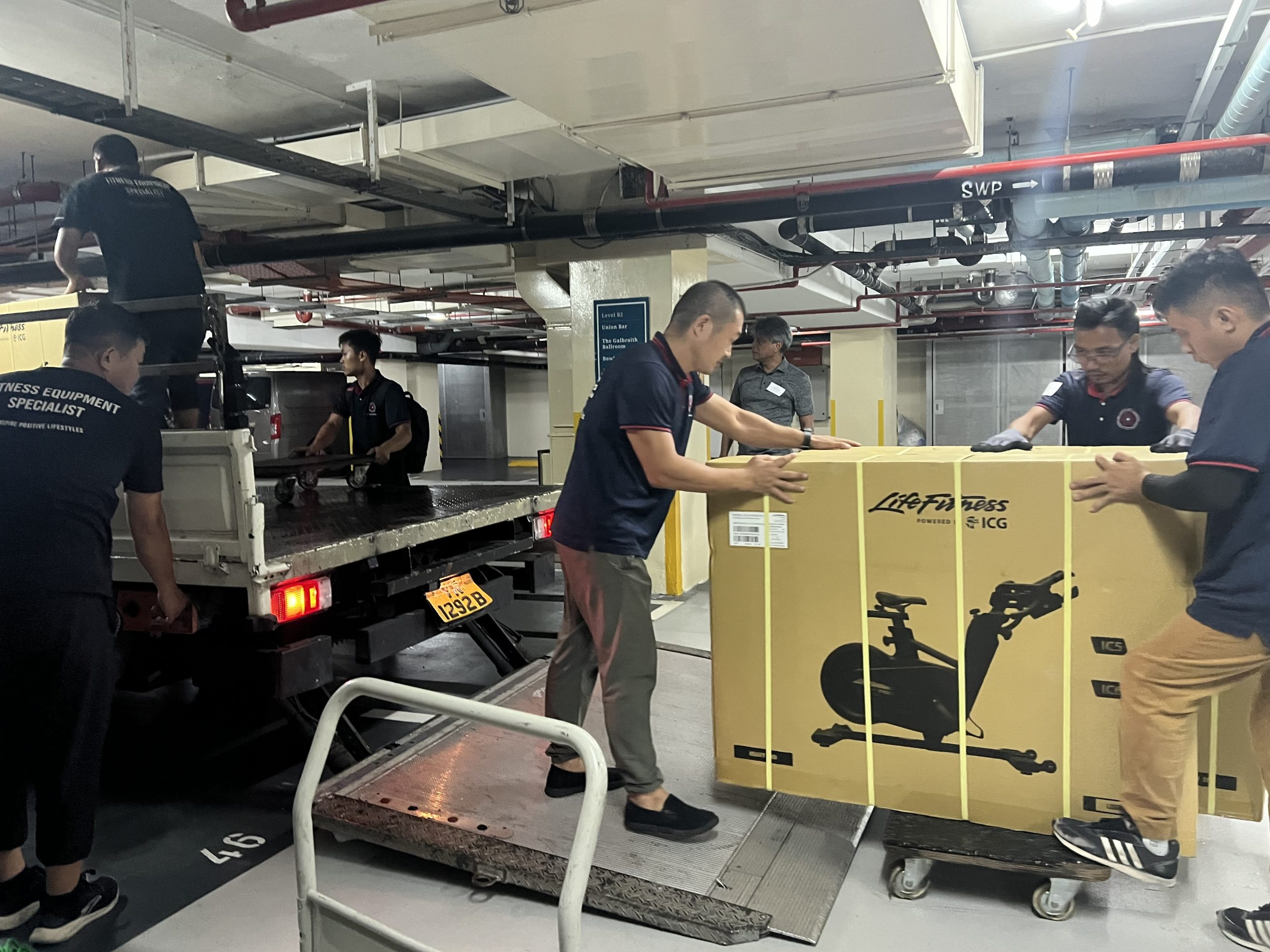 Commercial crew loading equipment and boxed items during a night office-clearance job in Singapore