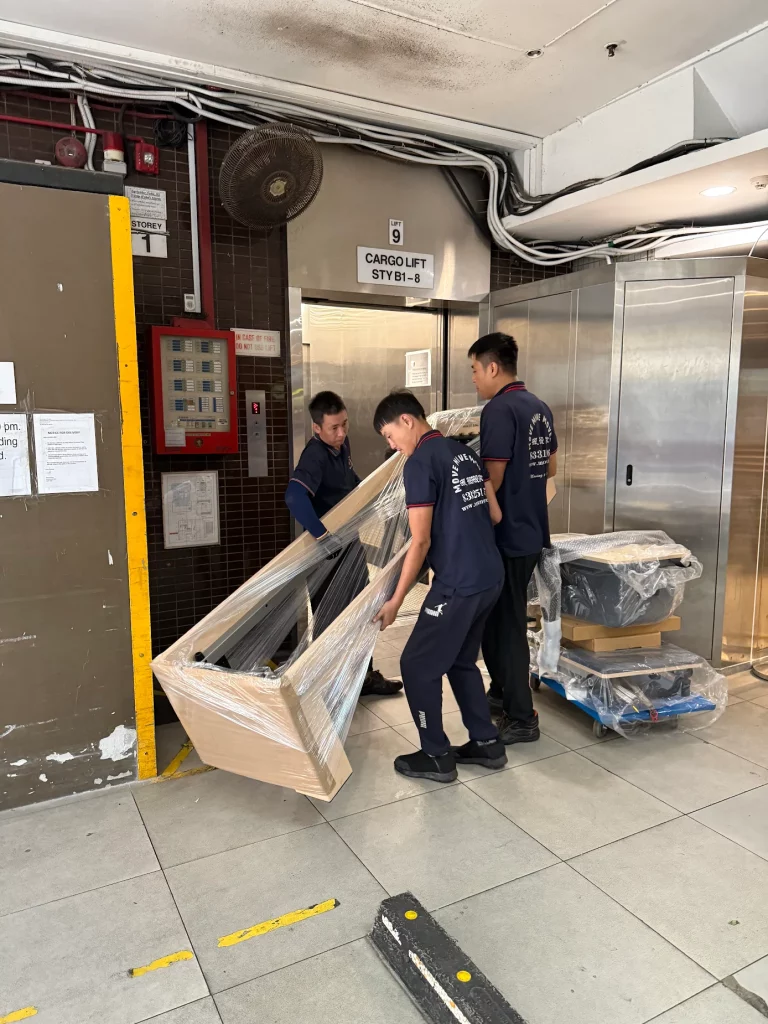 Move Move Movers crew carrying wrapped furniture near a cargo lift lobby