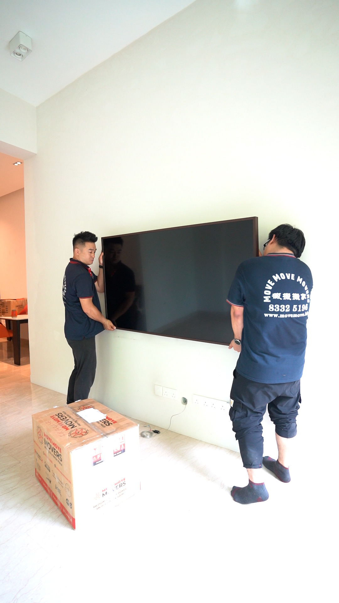 Crew carrying a large household item out during a residential clearance in Singapore