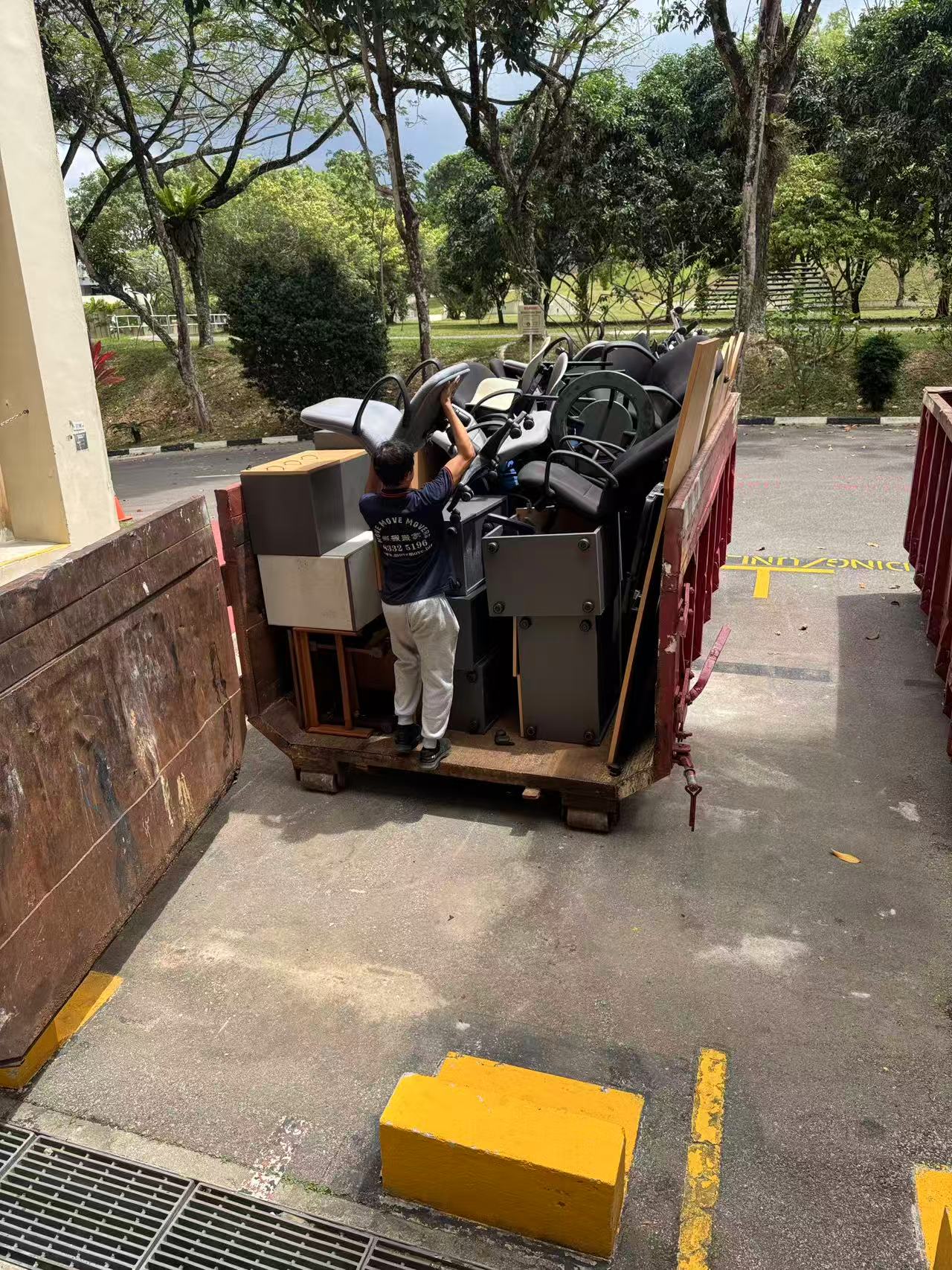 Skip tank filled with office chairs and mixed furniture for bulky disposal in Singapore