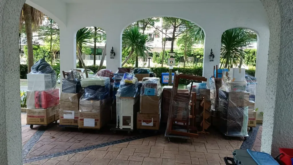 Wrapped furniture, boxes and household items staged on trolleys before removal