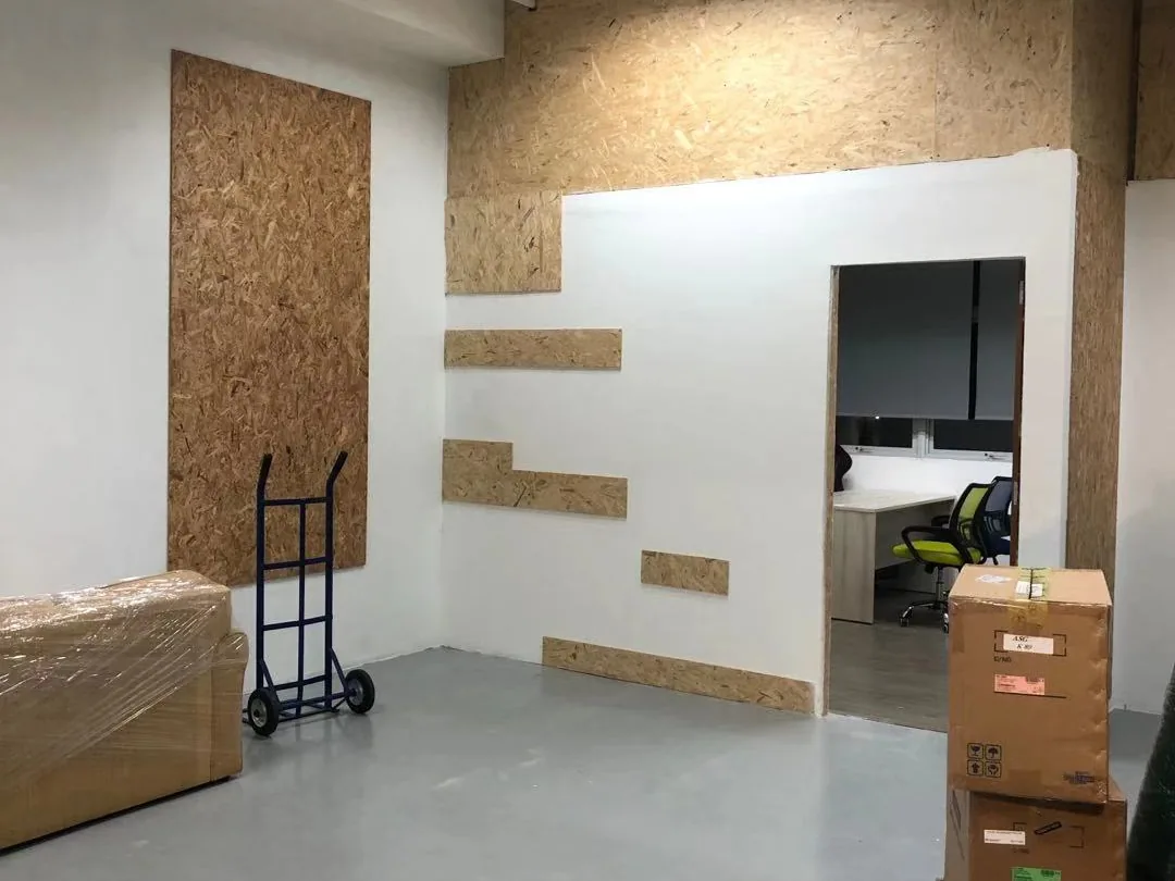 Mostly cleared commercial interior with a trolley, packed cartons and one remaining office chair